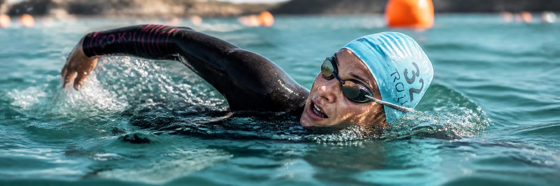 Mulher nadando em competição de triatlo, representando saúde esportiva e movimento
